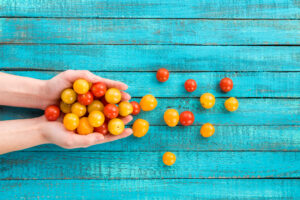 Leanbox Fresh Food Office DC, MD, VA - hands holding cherry tomato over blue table top