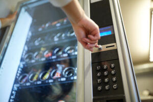 hand pushing button on vending machine